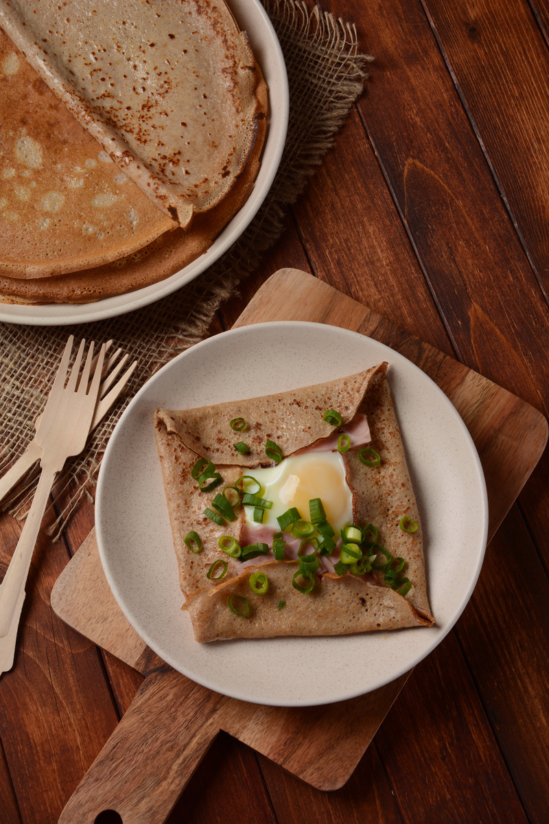Breton galette, galette sarrasin, buckwheat crepe, with fried egg, cheese, ham. French Brittany cuisine.